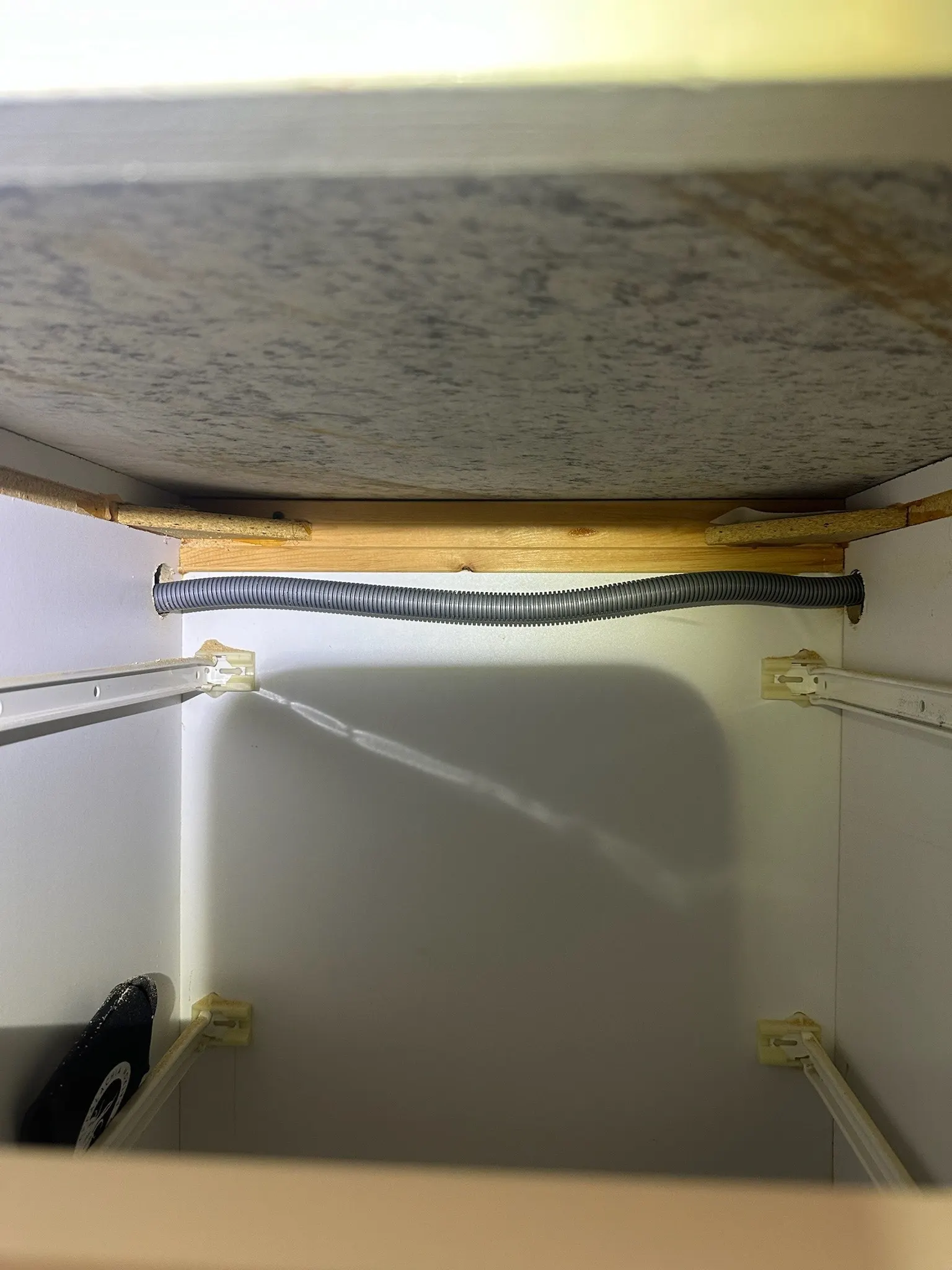 Properly routed dishwasher drain line secured under a kitchen cabinet photo 3