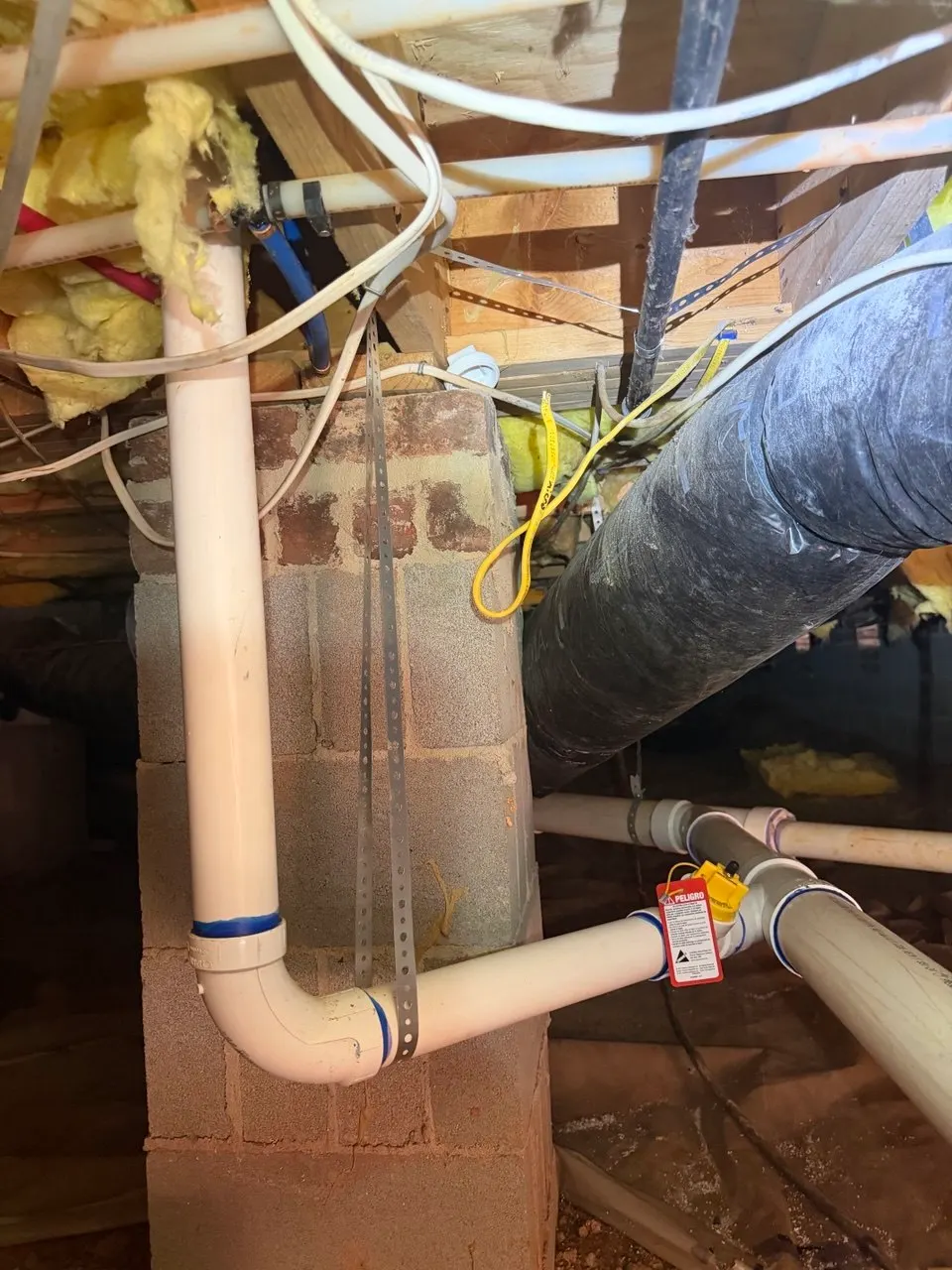 New PVC drain piping in the crawl space connected to the home’s existing drain line