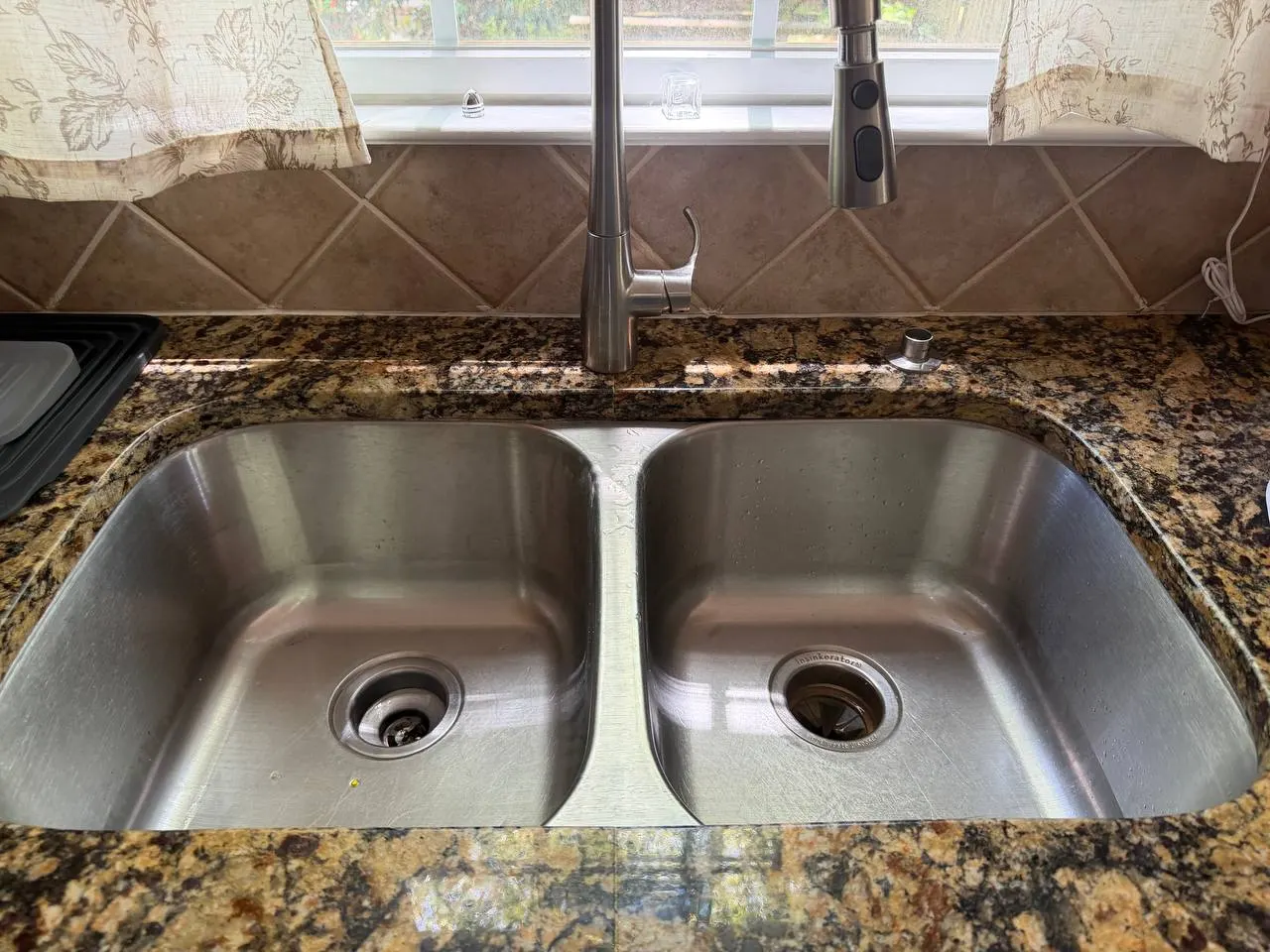 The original double-bowl stainless steel sink with two drains, before replacement