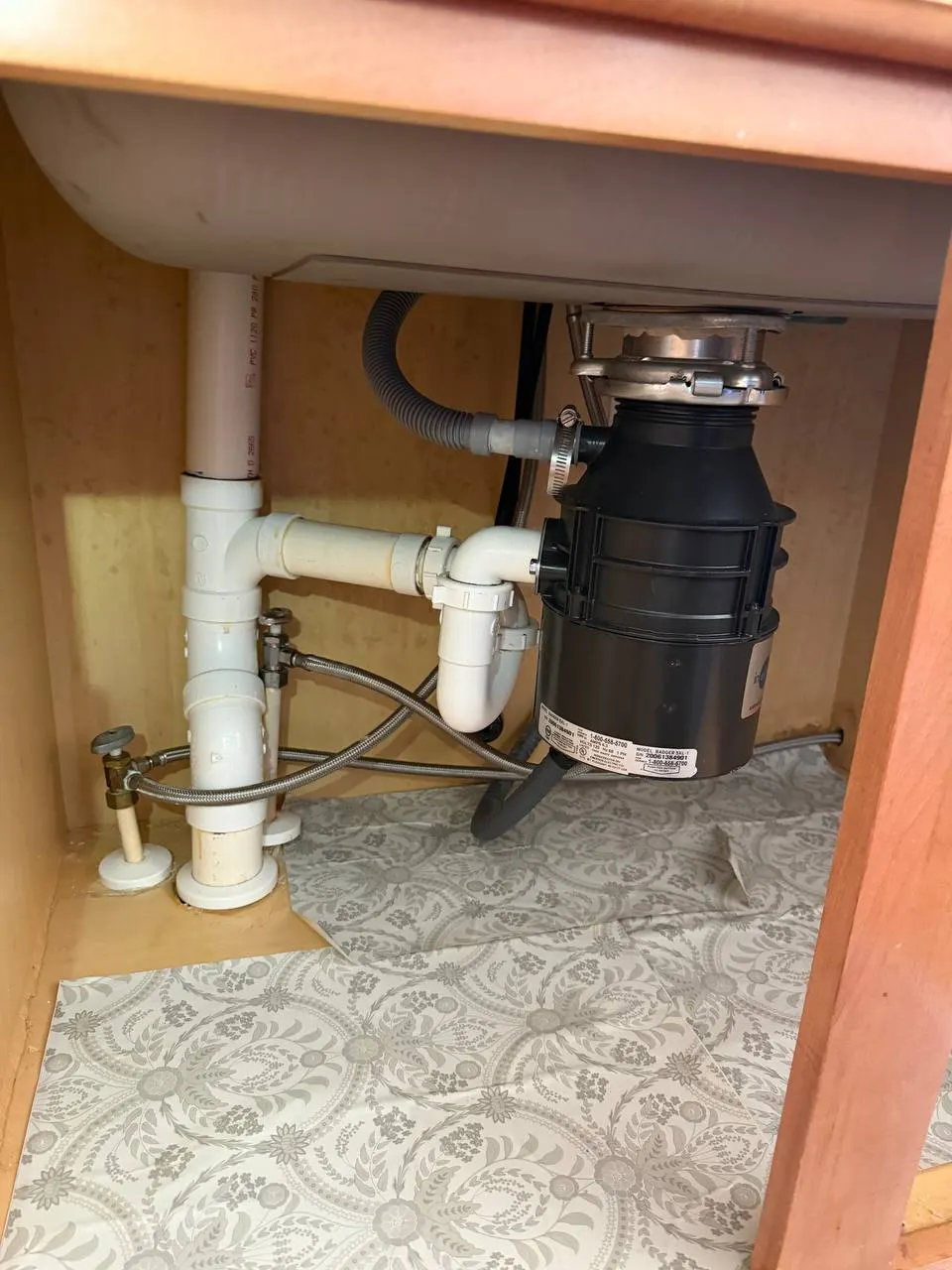 Reconfigured under-sink plumbing with the garbage disposal remounted at the new drain, a new P-trap and the dishwasher hose reconnected